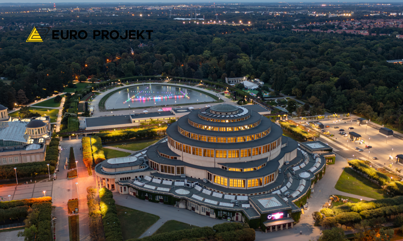 Hala Stulecia we Wrocławiu z lotu ptaka o zmierzchu, podświetlona kopuła i otoczenie